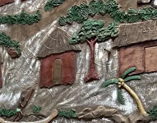 A carved round hut, trees and a palm on the mural